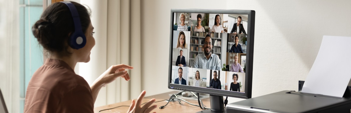 A woman is on a video conference call at her desk in an office.