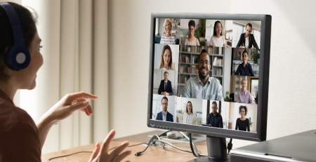 A woman is on a video conference call at her desk in an office.