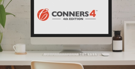 A computer on a desk with the Conners 4 logo displayed on the computer screen.