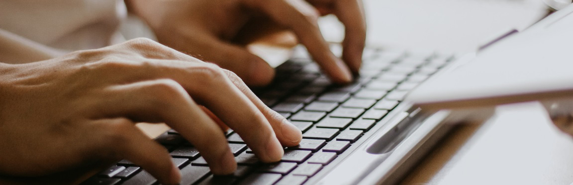 Hands typing on a keyboard.