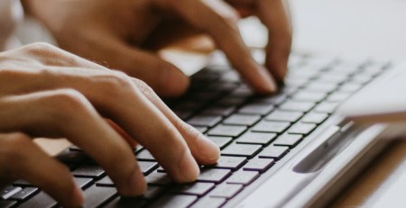 Hands typing on a keyboard.