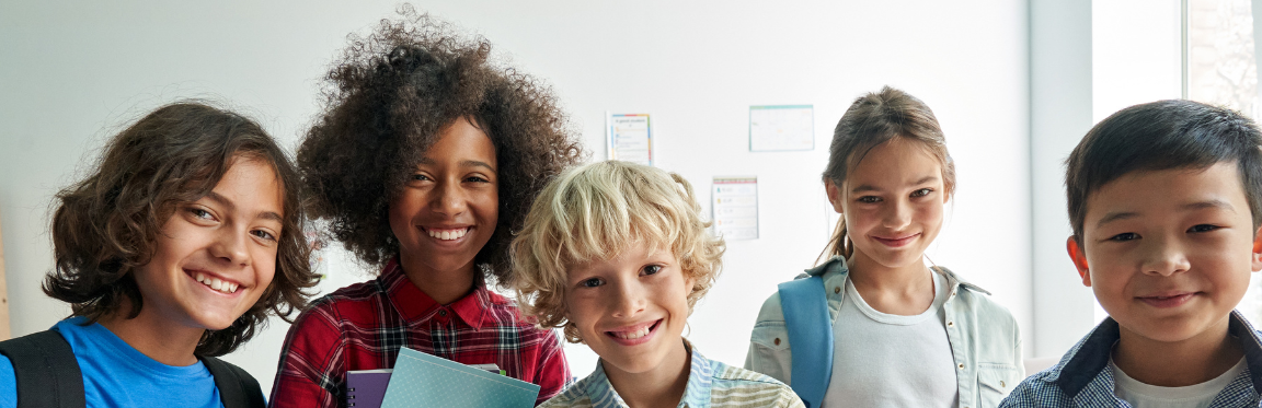 A group of young students smile for a photo.