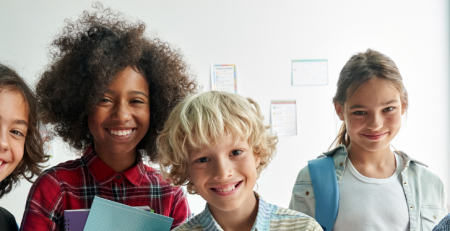 A group of young students smile for a photo.