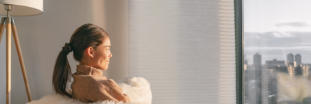 A woman relaxing at home and looking out the window.