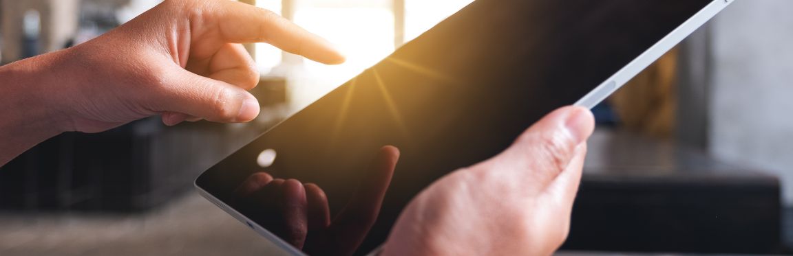 Hands holding an iPad and pointing to the screen.